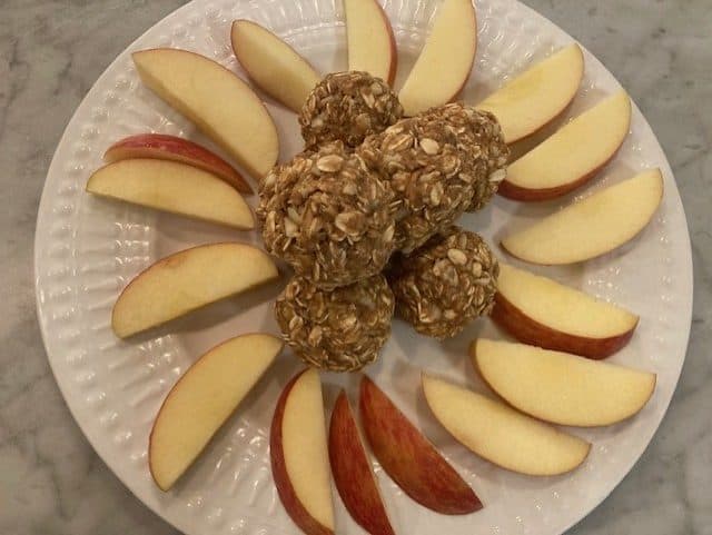 apple pie energy bals on plate with sliced apples