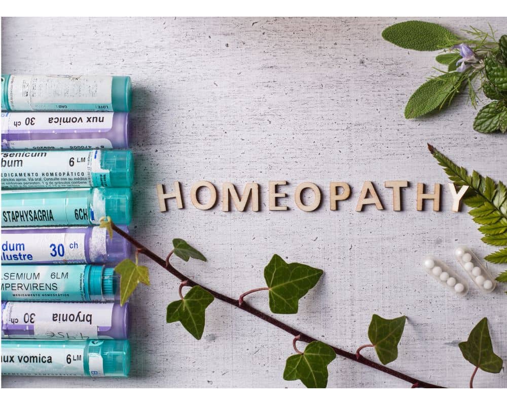 Bottles of homeopathic remedies surrounded by plants