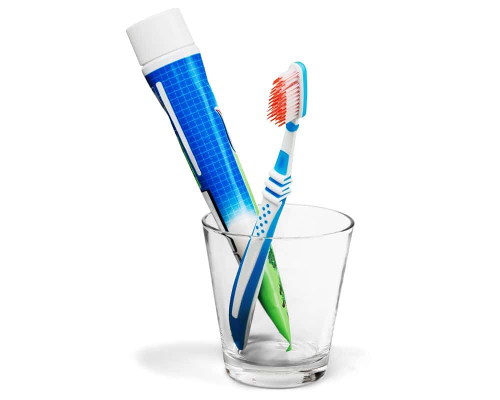 cup holding toothbrush and toothpaste