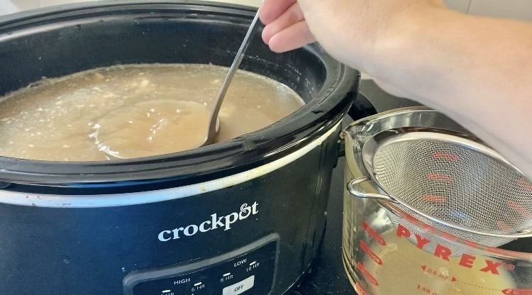 soup ladle dipping bone broth out of crockpot