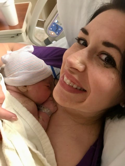 mom holding newborn in hospital bed