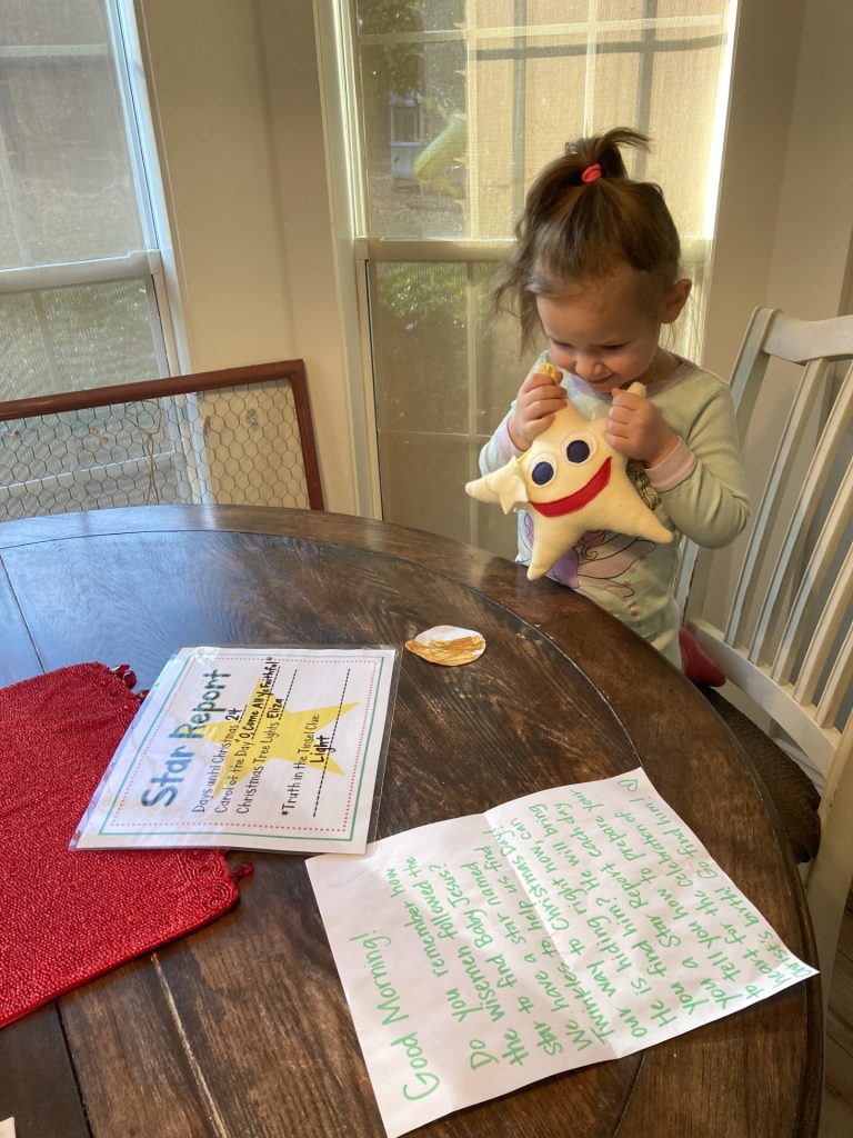 girl in pjs holding stuffed star