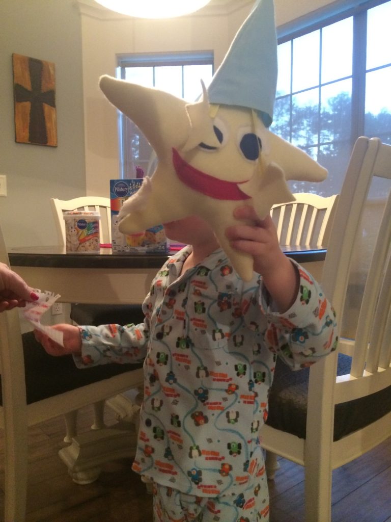 boy in pjs holding stuffed star