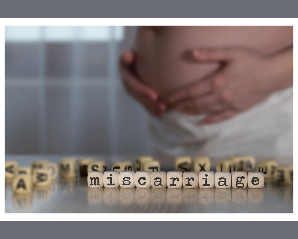 woman holding stomach with word "miscarriage"